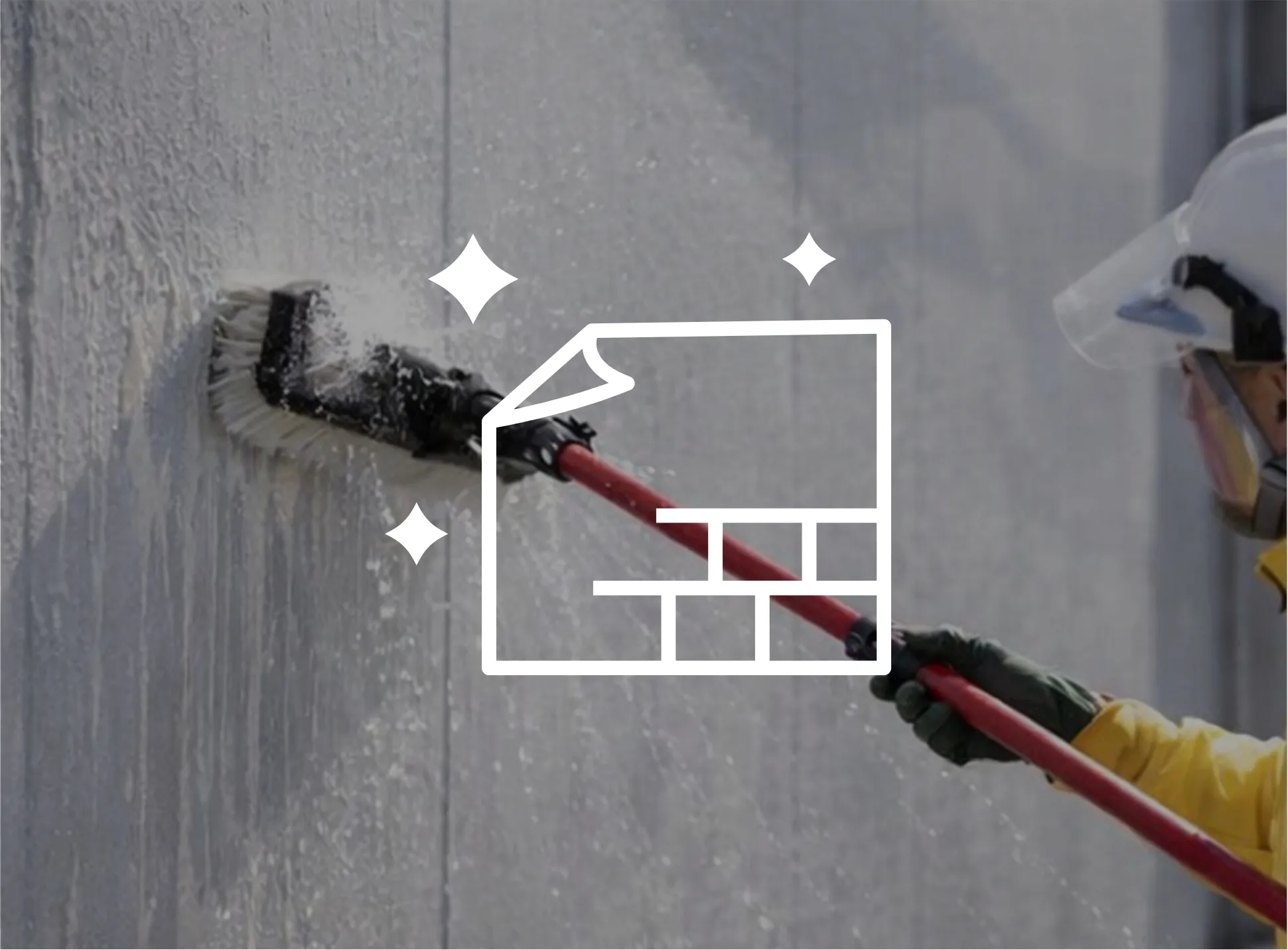 作業員がブラシで外壁洗浄をしている様子